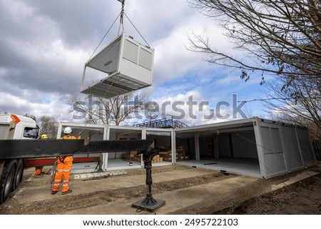 Construction Worker’s Assembling Modular Building. Shipping Containers Building Lifted into Position 2
