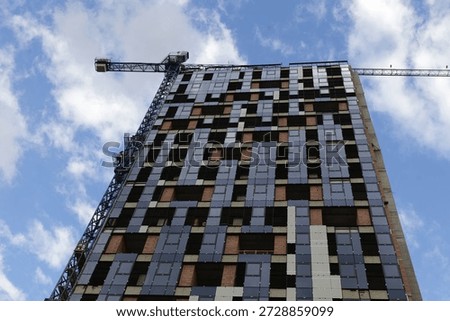 Construction of Avalon Tower in Sofia, Bulgaria. Modern residential high-rise with glass panels and brick elements, visible cranes and unfinished facade showing active building process, BG, 31 May 2025