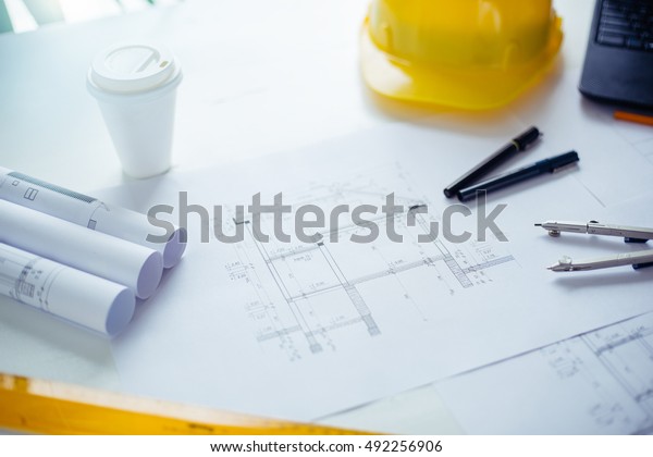 Construction\
blueprints and engineers\
equipment