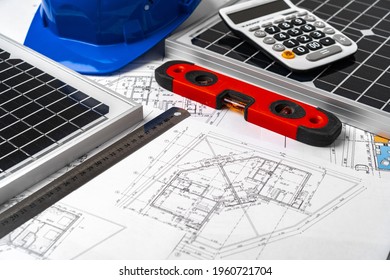 Construction Blueprints, Hardhat And Solar Battery On Architect's Table