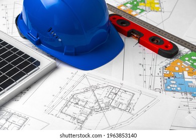 Construction Blueprints, Hardhat And Solar Battery On Architect's Table