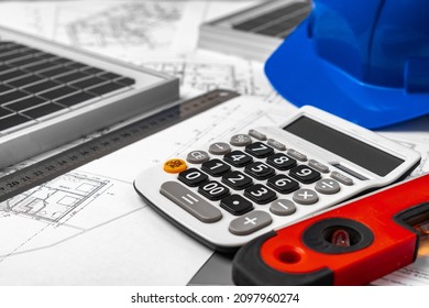 Construction Blueprints, Hardhat And Solar Battery On Architect's Table