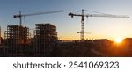 Construction boom in western Ukraine. A construction crane silhouetted against the warm glow of an early morning sky.