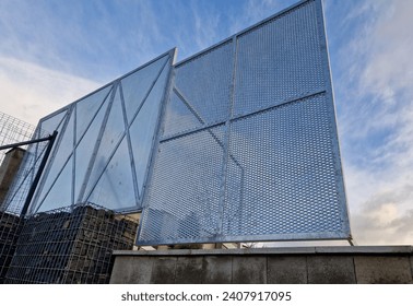 construction of a brick fence to prevent thieves from climbing into the garden. perforated metal sheet fence in the shape of squares with bracing against the wind, design, modern, windbreaker
