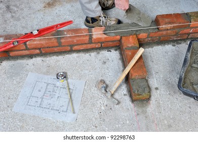 construction of a brick wall by a bricklayer