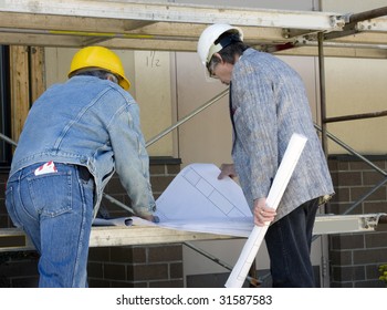 Construction Builder And Architect Review Blue Prints At Job Site