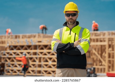 Construction builder in building uniform on buildings construction background. Builder at the construction site. Man worker with helmet on construction site. Bilder in hardhat.
