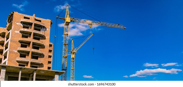 construction building process crane object brick house shape urban landmark photography foreshortening from below on vivid blue sky empty copy space for your text here 
