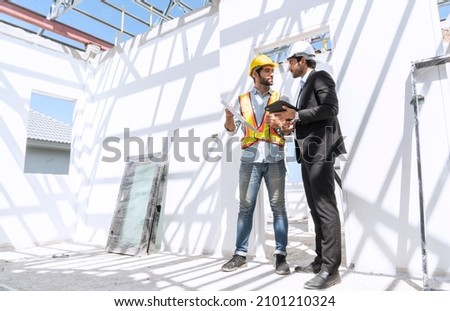 Construction and buliding concept.Foreman, a construction engineer, and a project manager talking to inspect the construction site and tablet to check the construction progress of the housing project.
