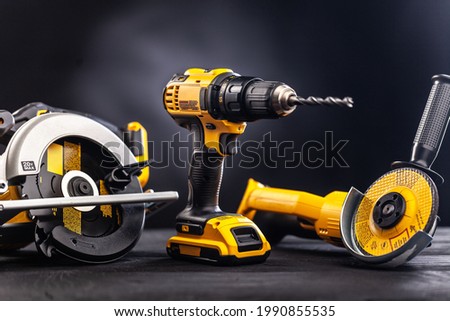 Construction carpentry tools electric corded circular saw cordless drill on background