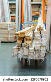 Construction Cart In The Building Store. Carts Loaded With Boards. Shop Of Building Materials. Racks With Boards, Wood And Building Material. Loaded Cart In A Hardware Store.