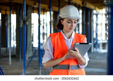 Construction concept of Engineer or Architect working at Construction Site. A woman with a tablet at a construction site. Bureau of Architecture. - Powered by Shutterstock