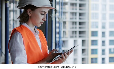 Construction concept of Engineer or Architect working at Construction Site. A woman with a tablet at a construction site. Bureau of Architecture. - Shutterstock ID 2111057246