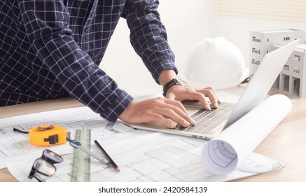 Construction concept Home architect reviews house plans Project at the construction site at the table in the office - Powered by Shutterstock