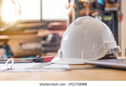 Construction concepts. White safety helmets blueprints on the engineering desks. Hard safety wear helmet hat on desks at construction site