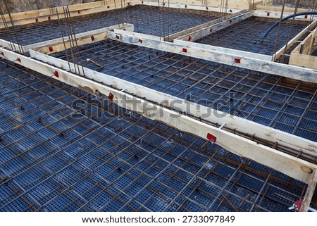 The construction of a concrete foundation using reinforcing steel prepared at the construction site.