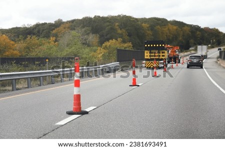 construction cone, standing alone on a sunlit urban street, symbolizing safety, roadwork, caution, and urban development