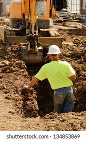 Construction Contractor Using A Small Track Hoe Excavator To Dig A Water Line Trench On A New Commercial Residential Development