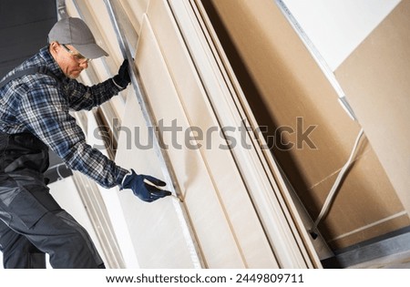Construction Contractor Worker Marking Cutting Place on a Sheet of a Drywall Panel