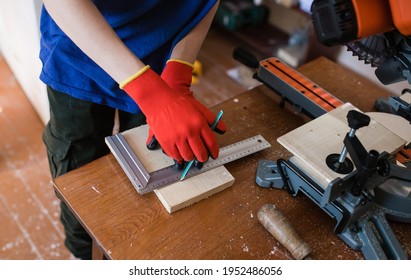 Construction contractor worker using a hand saw to cut planks on a new home construction project. carpentry shop