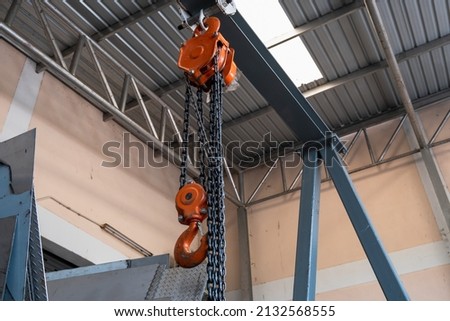 The construction crane in factory. chain hoist hanging on steel box
