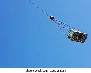 construction crane lift basket against blue sky