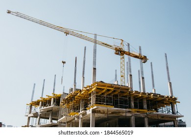  construction crane on the background of the tops of the house and the blue sky
