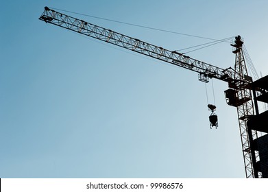 Construction crane  silhouette over sun