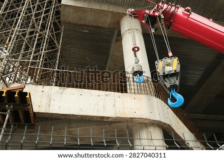 Construction Crane with Steel Framework and Copy Space. A large construction crane stands on the right side of an active building site, with steel structures and scaffolding extending across the opposite side. Open space creates a strong composition for articles about urban development, engineering, construction, and infrastructure.