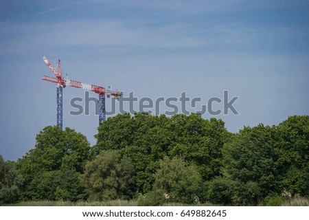 Construction crane towering above the trees, city and nature, cranes, Bordeaux, France