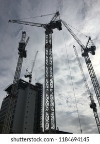 Construction cranes against the backdrop of cloudy skies