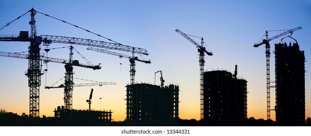 construction cranes silhouette sunset
