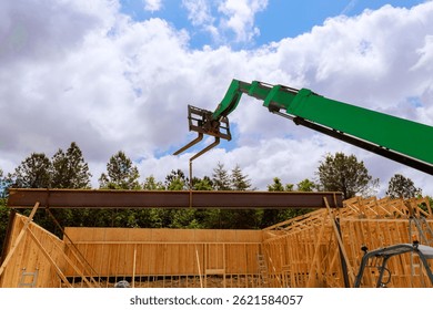 Construction crew uses telehandler crane to hoist steel beam into place near wooden frame structure