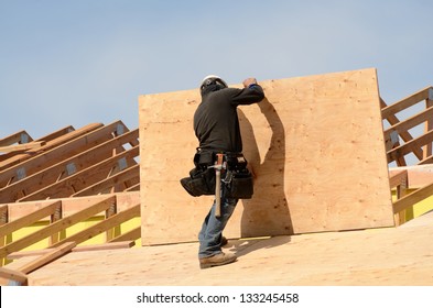 Construction Crew Working On The Roof Sheeting Of A New, Two Story, Commercial Apartment Building In Oregon