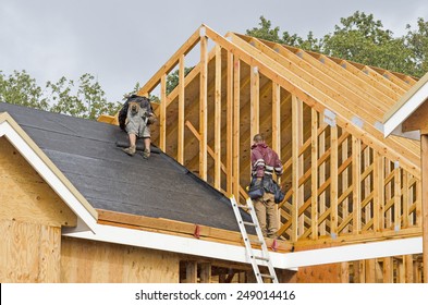 Construction Crew Working On The Roof Sheeting Of A New, Luxury Residential Home Project In Oregon