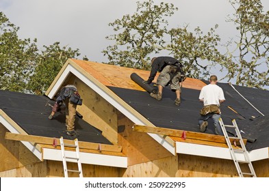 Construction crew working on the roof sheeting of a new, luxury residential home project in Oregon