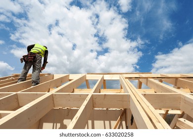 Construction Crew Working On The Roof Against Blue Sky