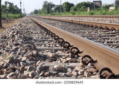 Construction of dual high-speed railway tracks with cement concrete beams and overhead power lines is underway, passing through dry grass terrain during the summer - Powered by Shutterstock