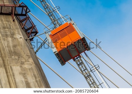 Construction elevator, lifts workers towards the new cable-stayed bridge under construction. Construction equipment. 
