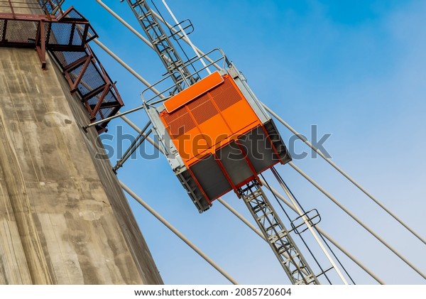 Construction\
elevator, lifts workers towards the new cable-stayed bridge under\
construction. Construction equipment.\
