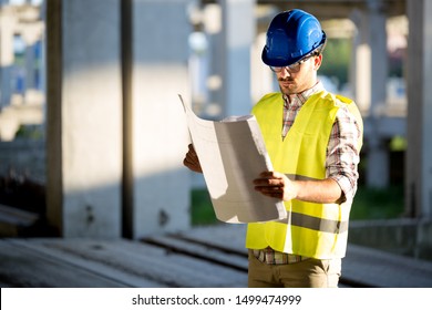 Construction engineer in hardhat with project in hands