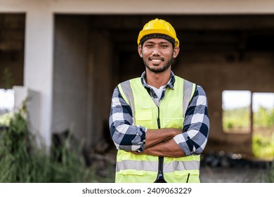 construction engineer in a high-visibility vest holding a blueprint and a walkie-talkie, possibly coordinating or inspecting a construction site. - Powered by Shutterstock