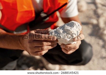 Construction engineer inspecting limestone rocks at open mining site. Concept of raw building materials and industry