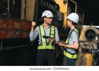 Construction engineer maintenance technician safety vest hard hat industrial machinery factory inspection tablet teamwork discussion Construction engineer and maintenance technician wearing safety