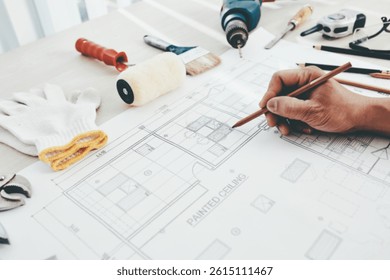 Construction engineer making final corrections in building blueprint or checking size of every detail