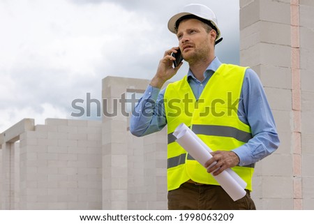 construction engineer supervisor working at building site. talking on the phone
