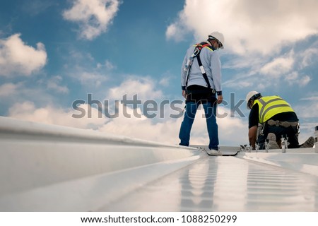 Construction engineer wear safety uniform inspection metal roofing work for roof industrial concept with copy space