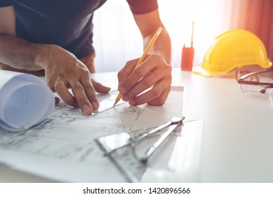 Construction Engineer Working At Blueprint To Build Large Commercial Buildings At Home