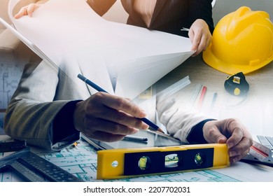 Construction Engineer Working At Blueprint To Build Large Commercial Buildings In Office. Engineering Tools And Construction Concept.