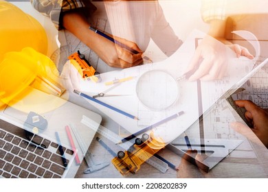 Construction Engineer Working At Blueprint To Build Large Commercial Buildings In Office. Engineering Tools And Construction Concept.